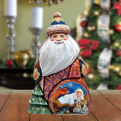 A wooden Santa Claus figurine with a nativity scene inside, set against a blurred background with Christmas decorations.