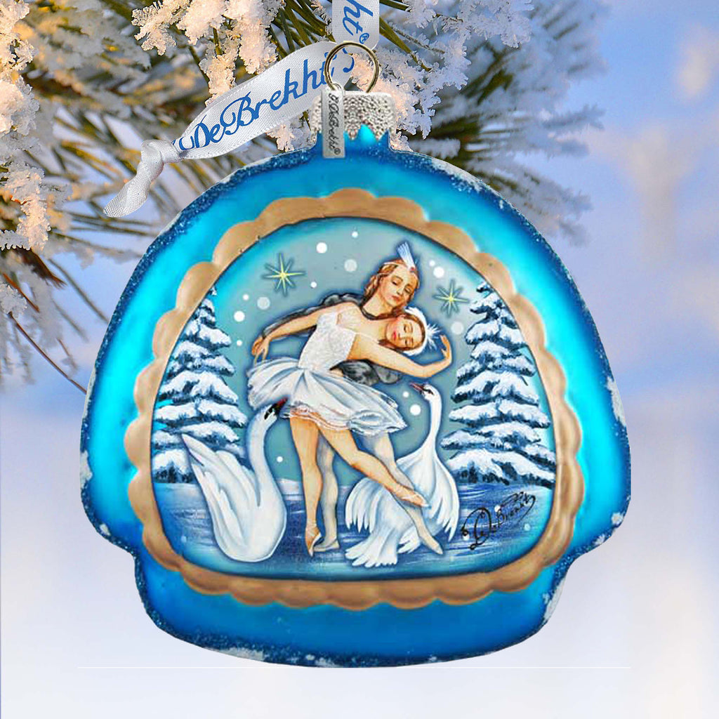 A blue ornament with a white swan and snowflakes, featuring a woman in a white dress dancing with the swan.