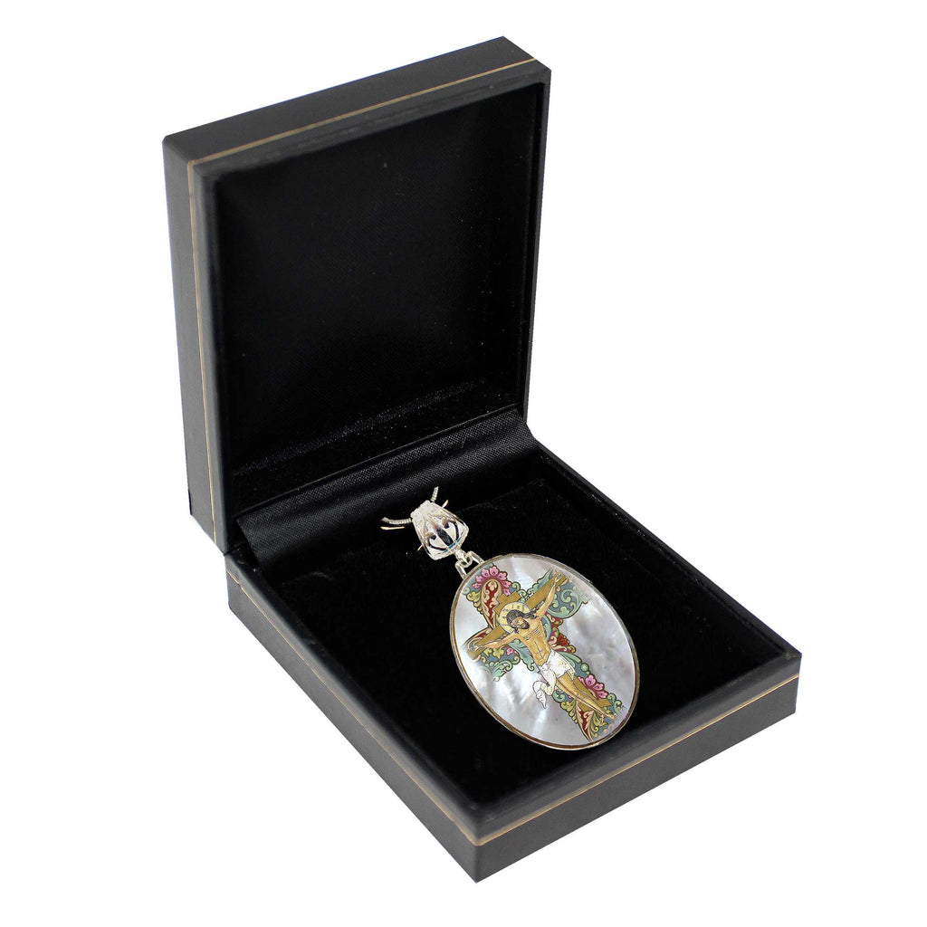 A black jewelry box containing a decorative oval pendant with a colorful design.