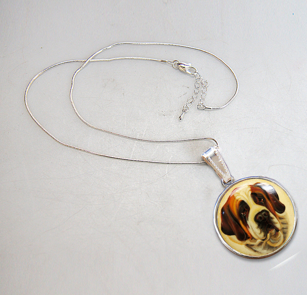 A silver necklace with a pendant featuring a dog's face.