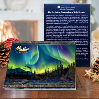 a large Alaska magnet with a stunning image of the Northern Lights, accompanied by a smaller card with text describing the magnet. The magnets are placed on a table with pine cones and star anise, creating a festive and holiday-themed display.