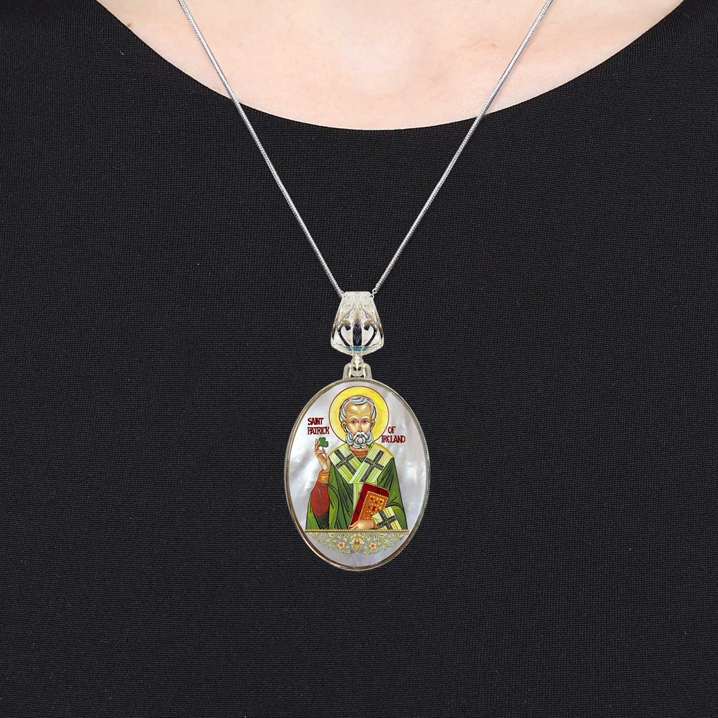 A silver necklace with a pendant featuring an oval-shaped image of a religious figure, likely a saint or religious icon.