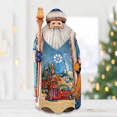 A figurine of Santa Claus holding a staff and a nativity scene depicting the birth of Jesus Christ.
