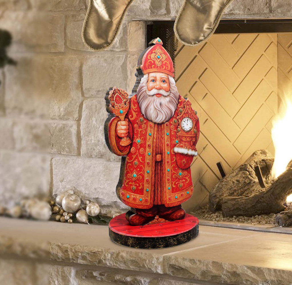 A wooden Santa Claus figurine is displayed on a red base in front of a fireplace.