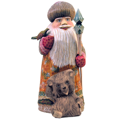 A wooden sculpture of Santa Claus holding a teddy bear.