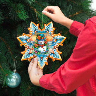 a person holding a snowflake ornament in front of a christmas tree
