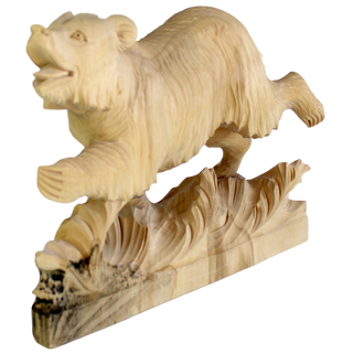 A wooden carving of a bear in mid-stride, with its mouth open and legs spread, is depicted on a wooden base.