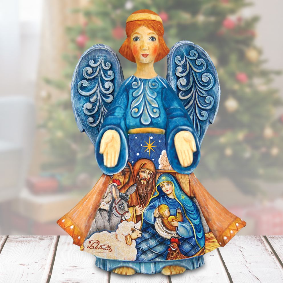 A hand-painted wooden angel figurine with blue wings and a blue dress, featuring a nativity scene with a baby Jesus, Mary, and Joseph.