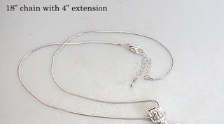 A silver 18-inch chain with a 4-inch extension necklace is shown on a white surface.