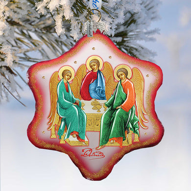 a decorative ornament with a religious theme, hanging on a branch with snow.