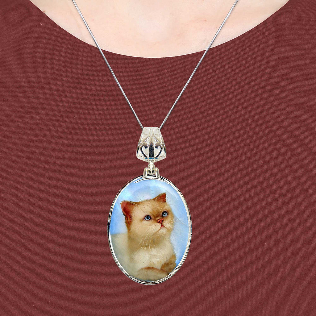 A silver necklace with a pendant featuring a picture of a cat.