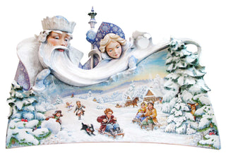 The image is a detailed and colorful depiction of a winter scene, featuring a large snowman, a Santa Claus figure, and various other figures enjoying the snowy landscape.