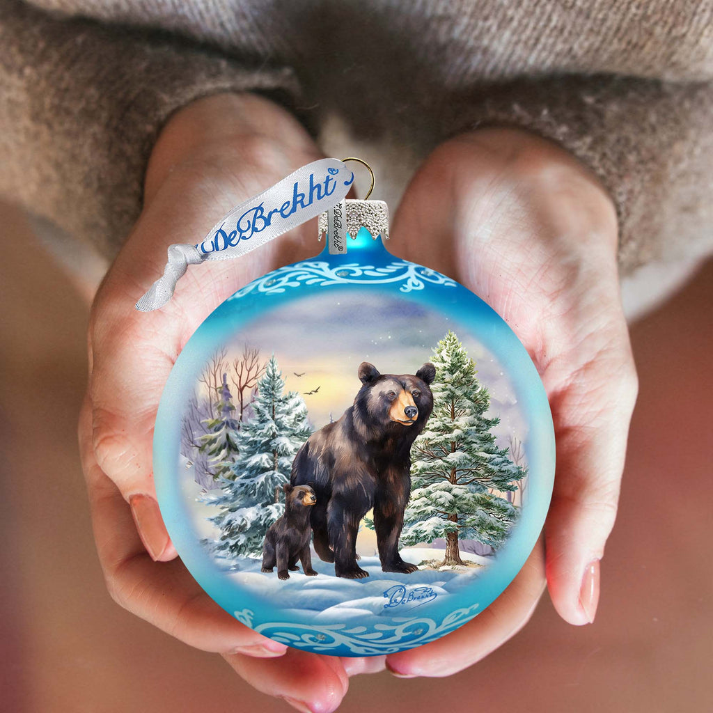 a person holding a bear ornament in their hands