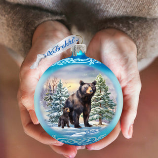 a person holding a bear ornament in their hands