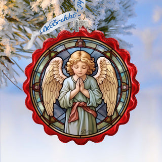 a stained glass angel ornament hanging from a christmas tree