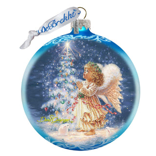 a glass ornament with an angel holding a christmas tree