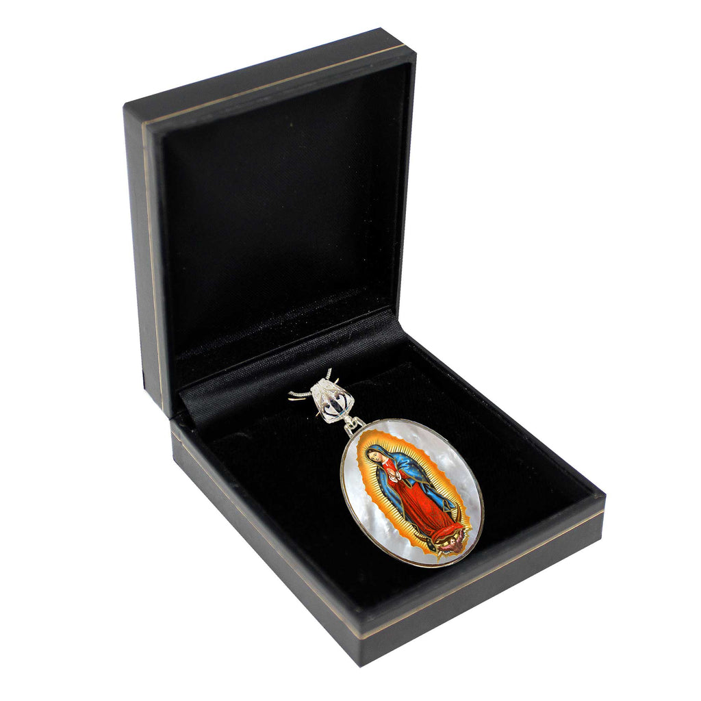 A pendant with a religious figure, likely a saint or deity, is displayed in a black jewelry box.