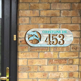 Oval coastal address plaque featuring dolphin cutout, house number 453, and customizable COASTLINE DR. street name, handcrafted by GDebrekht Artistic Studio. Perfect for nautical house numbers, coastal door decoration, beach house decor, and outdoor holiday decorations.