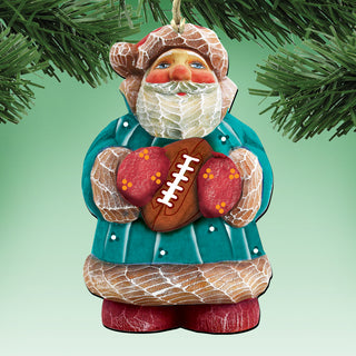 A Christmas ornament in the shape of a bearded man holding a football, wearing a green coat and red gloves, hanging on a tree branch.