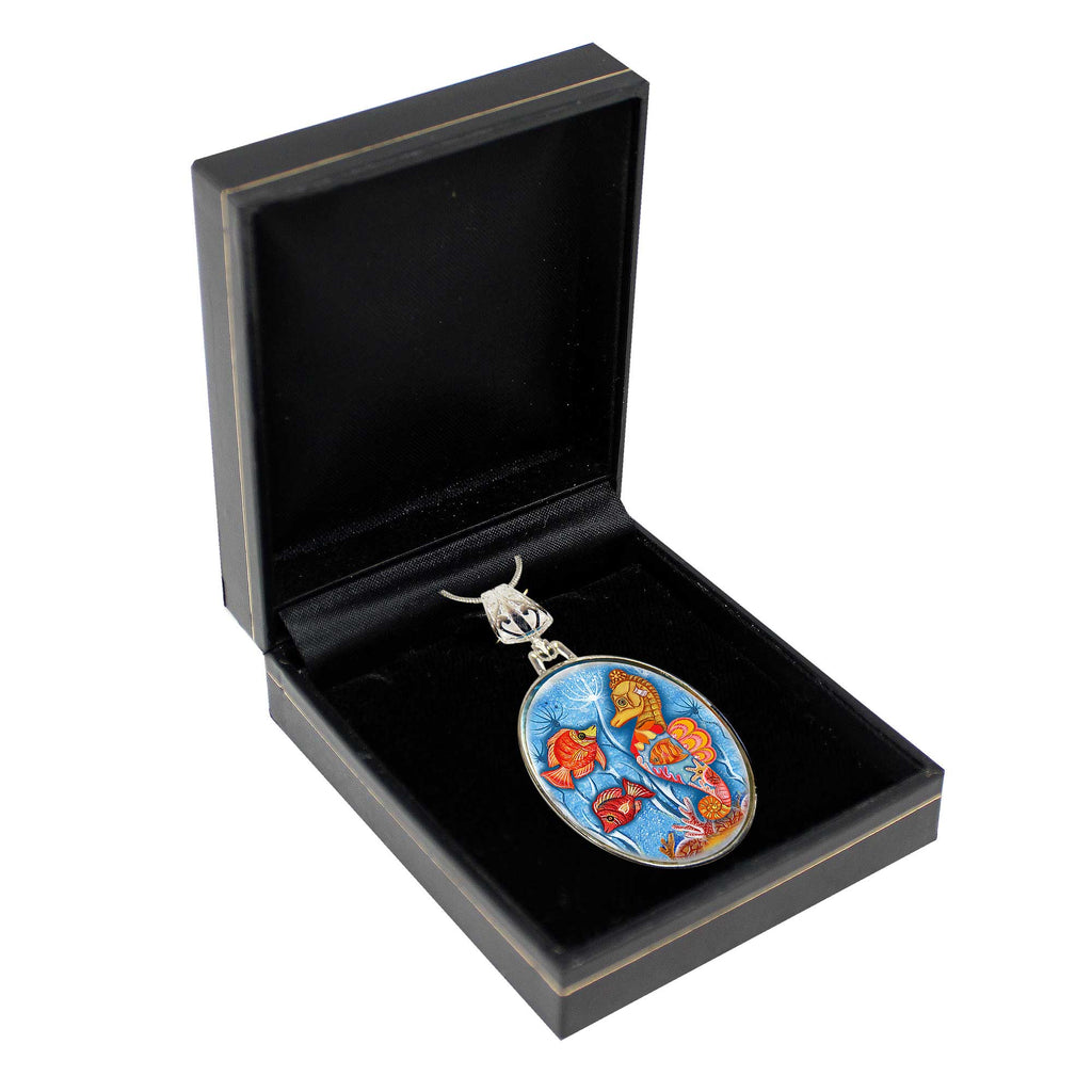 A pendant with a colorful design is displayed in a black jewelry box.