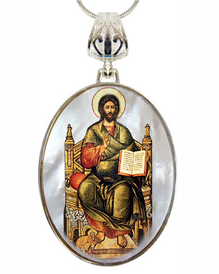 a pendant with a religious icon of Jesus Christ, who is depicted in a seated position with a book in his hand.