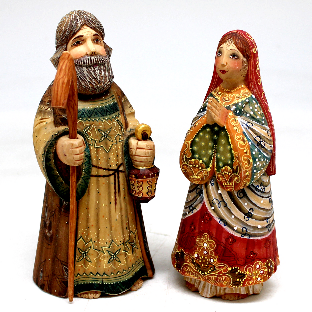 Two intricately carved figurines depicting a man and a woman, likely representing a religious or cultural figure.