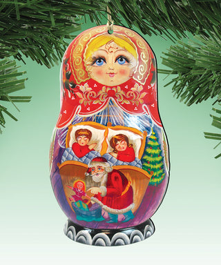 A colorful ornament featuring a painted doll with a red dress and a golden headpiece, surrounded by Christmas-themed elements such as a Santa Claus figure, a Christmas tree, and other holiday decorations.