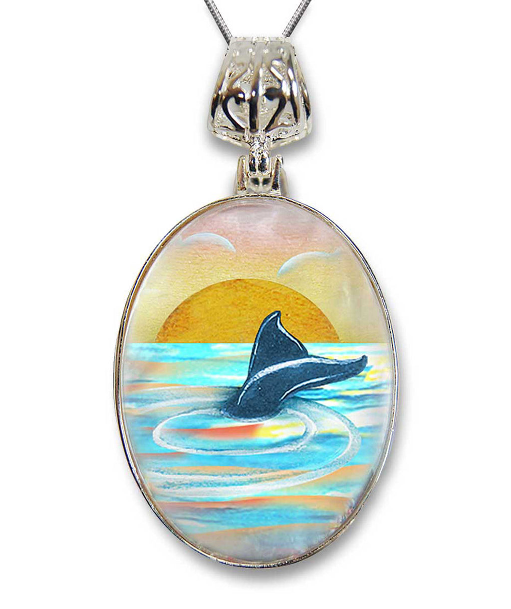 A pendant necklace with a glass pendant featuring a painting of a dolphin swimming in the ocean at sunset.
