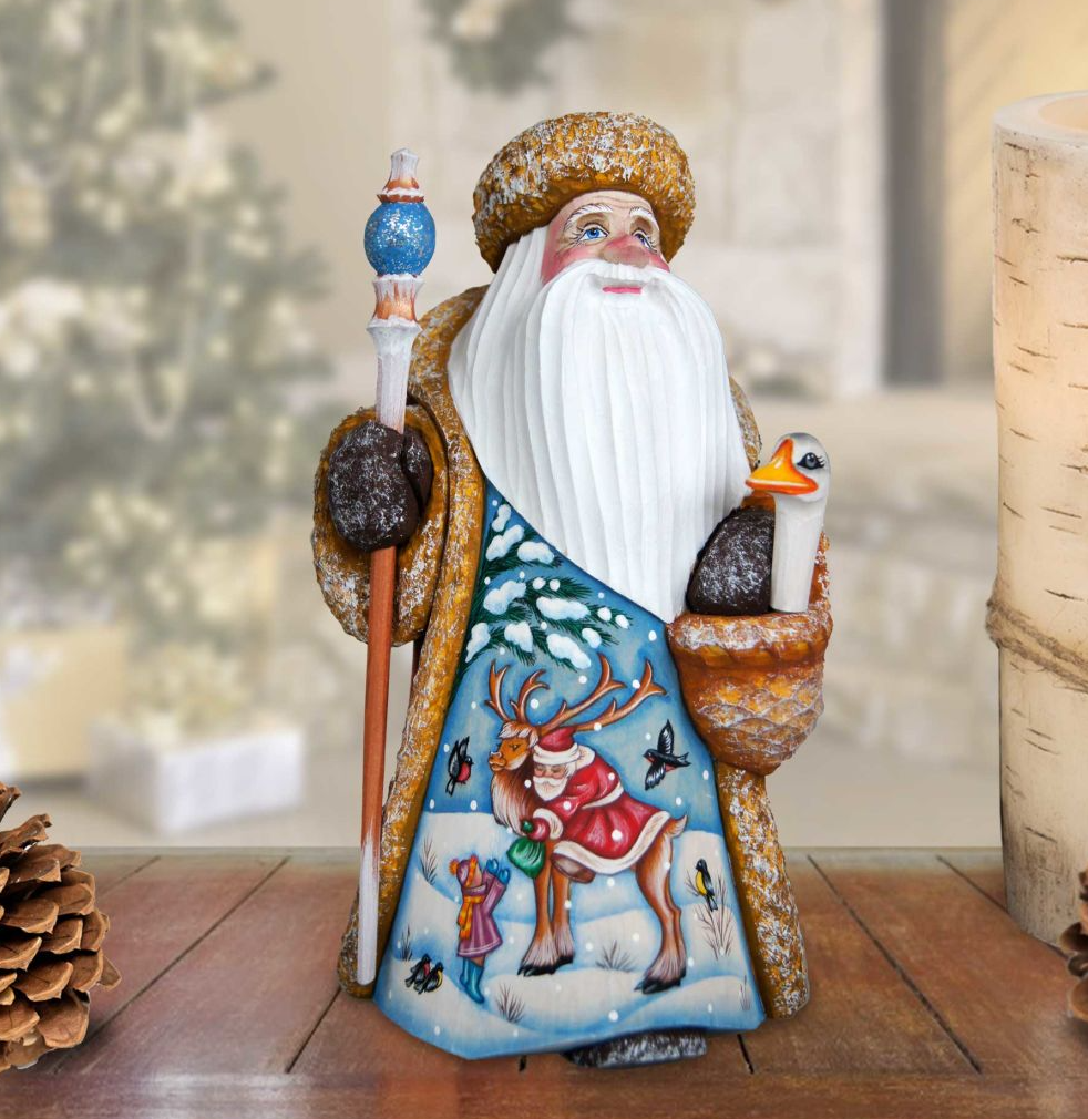 A colorful figurine of Santa Claus holding a reindeer and a bird, set against a snowy background.