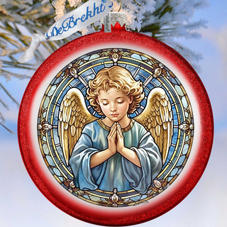 A red ornament with a stained glass design depicting a praying angel, hanging on a tree branch.