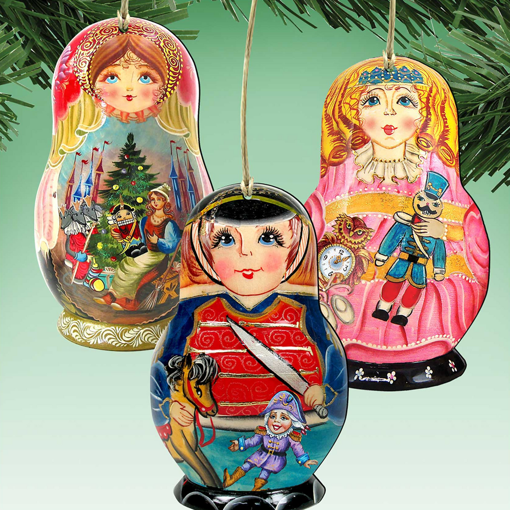 three colorful Russian nesting dolls or figurines hanging from a string, each with a unique design and theme.