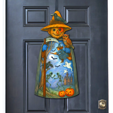 A Halloween-themed door decoration featuring a scarecrow figure with a hat, holding a scythe and a bird, and a castle, jack-o-lanterns, and skeleton figures.
