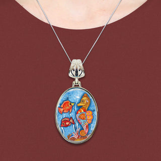 A necklace with a pendant featuring a colorful underwater scene with fish and coral.