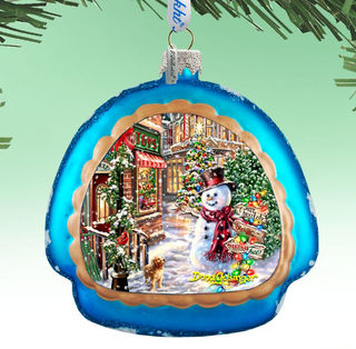 A blue ornament with a snowman and Christmas trees, featuring a small dog and a red scarf.