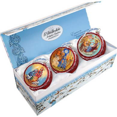 A set of three decorative Christmas ornaments in a blue box, each with a unique design.