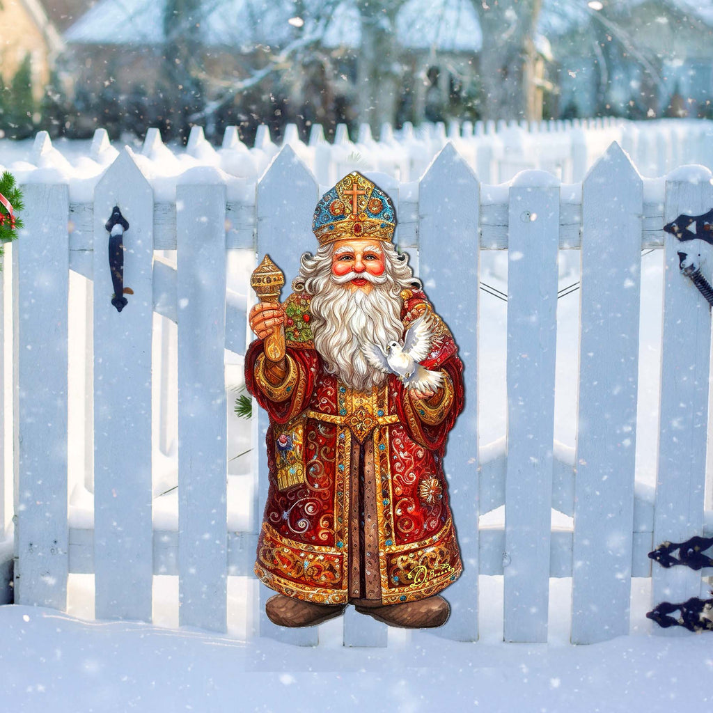 a statue of a santa claus holding a candle in the snow