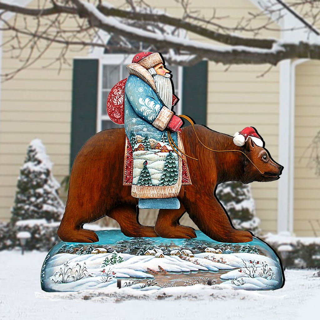A wooden bear statue dressed in a Santa Claus outfit is depicted riding a bear in a snowy landscape.