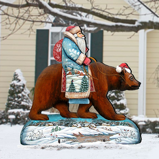 A wooden bear statue dressed in a Santa Claus outfit is depicted riding a bear in a snowy landscape.