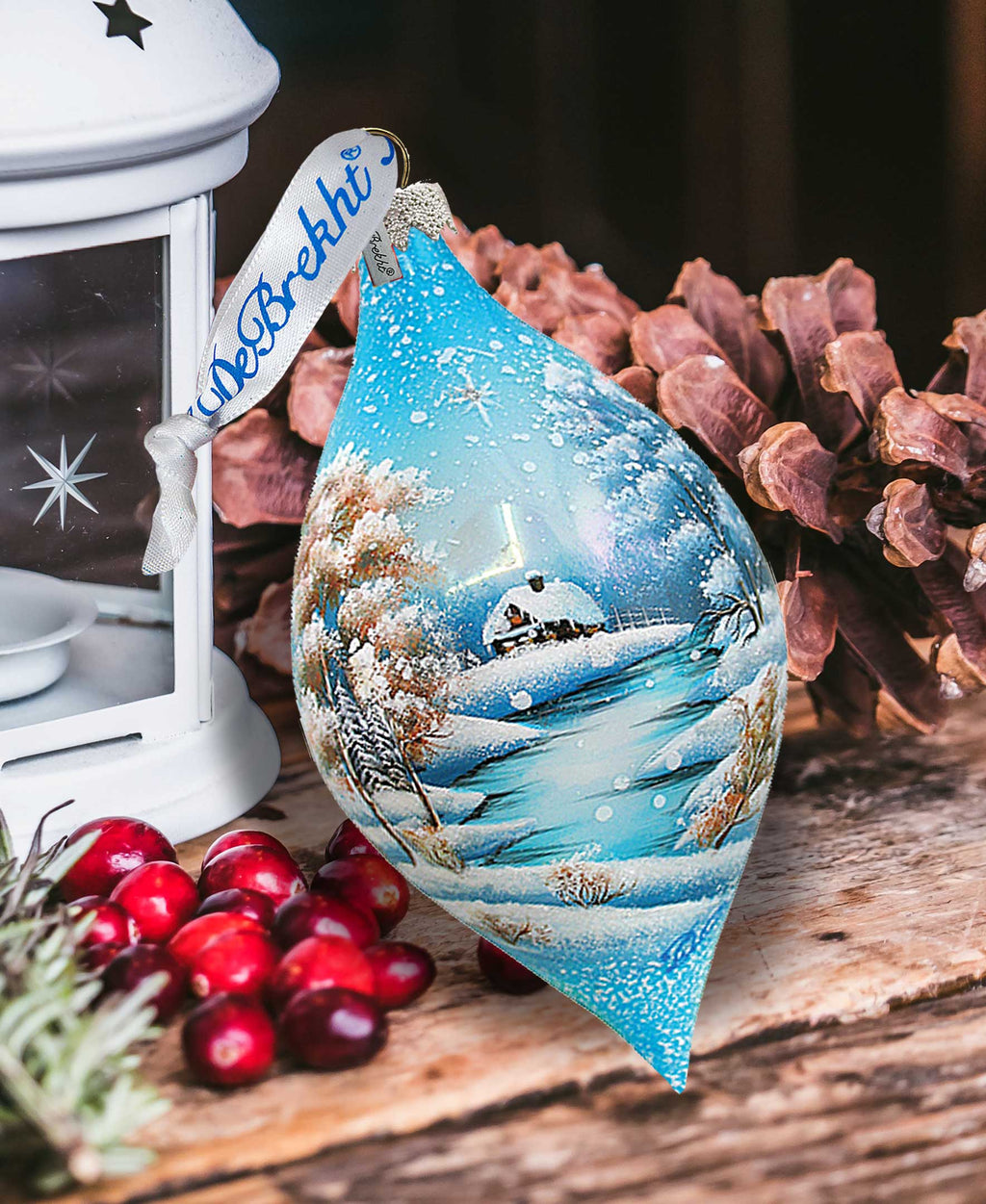 a christmas ornament sitting on a table next to a pine cone