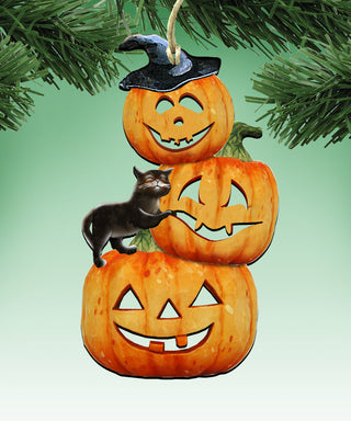 A Halloween-themed ornament with three carved pumpkins and a black cat perched on top of one of the pumpkins.