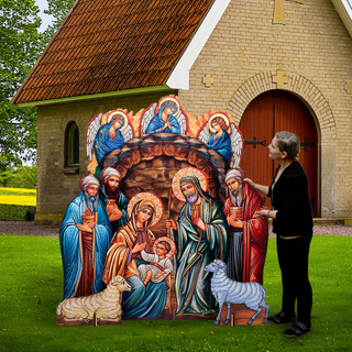 A woman is standing next to a large cardboard nativity scene depicting the birth of Jesus Christ, with various religious figures and symbols.