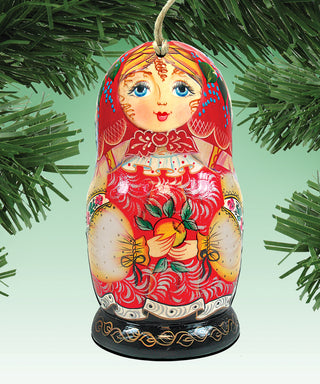 A colorful, intricately painted nesting doll ornament hanging on a tree branch.