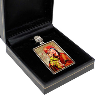 a pendant with a religious icon, such as a depiction of a saint or religious figure, displayed in a black box.