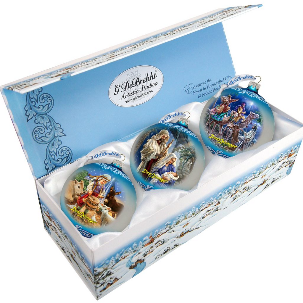 A set of three ornaments in a blue box, each depicting a different scene from the nativity story.