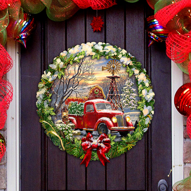 A wreath with a red truck and a windmill in the background, surrounded by Christmas decorations and ornaments.