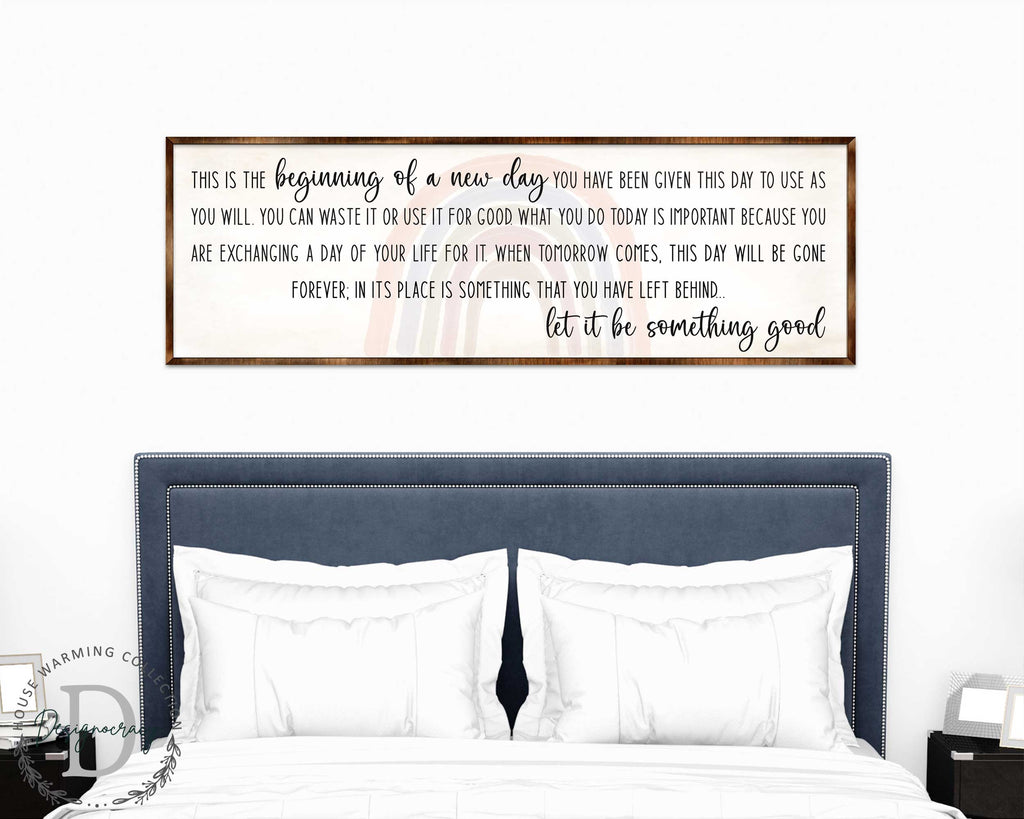 a bedroom setting with a bed and a framed inspirational quote on the wall above it.