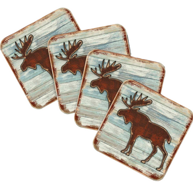 four square coasters with a moose silhouette design on a blue and white wooden background.