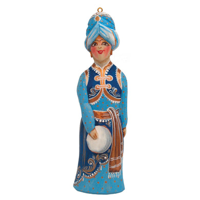 A figurine of a person wearing a turban and holding a white object, possibly a musical instrument or a decorative item.