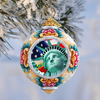 A decorative ornament featuring the Statue of Liberty, with a colorful and intricate design surrounding the iconic figure.