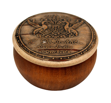 A wooden bowl with a decorative lid featuring a crest and text.